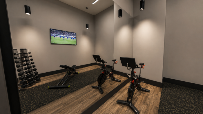 Magnolia Person practicing yoga in a bright, modern fitness room with wooden floors, mirrors, and gym equipment on the wall.